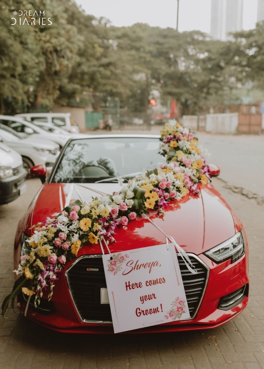 Red bridal car decorated with colorful flowers