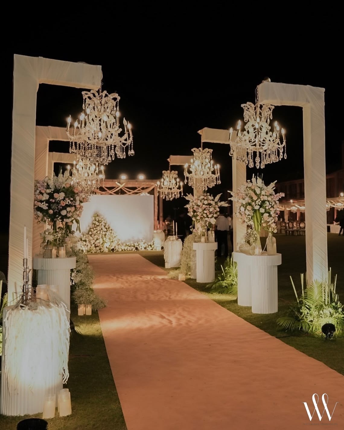 Outdoor event passage with chandeliers and flowers